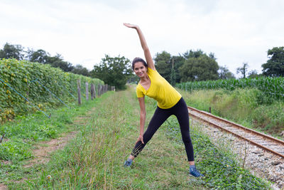 Full length of woman jumping on field