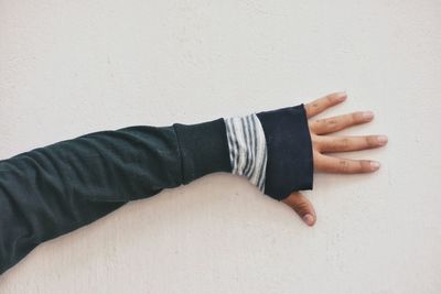 Cropped hand of man touching white wall