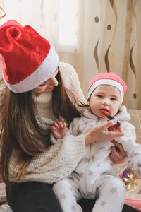 Cheerful other applying lipstick to daughter