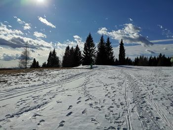 Scenic view of snow covered land against sky