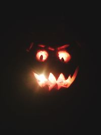 Close-up of lit candle in dark room