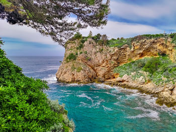 Rock formations by sea against sky