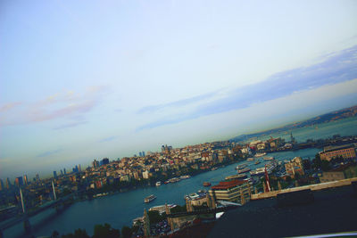 High angle view of city by sea against sky