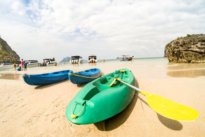 Boats moored on beach against sky