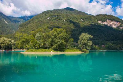 Scenic view of lake by mountains against sky