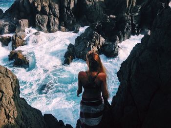 Woman standing on rocks at seaside