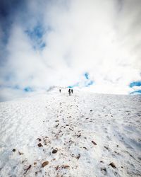 People on snow covered mountain against sky