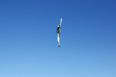 Low angle view of helicopter flying in clear blue sky