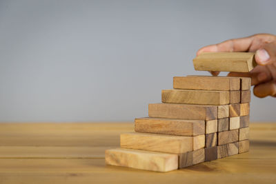 Close-up of hand holding toy on wooden table