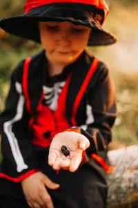 Boy wearing costume during halloween holding blackberries at forest