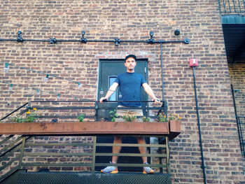 Portrait of young man standing on wall