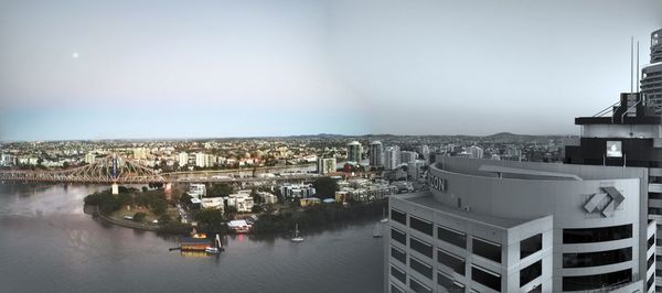 Aerial view of city by sea against sky