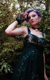 Portrait of woman standing against plants