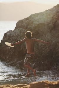 Man standing on rock at beach