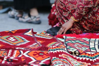 Low section of woman selling carpets 
