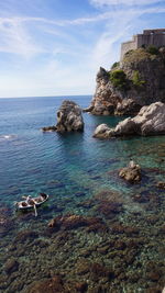 Rocks in sea against sky