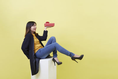 Side view of woman standing against gray background