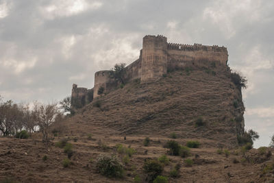 Low angle view of fort against cloudy sky