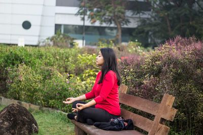 Side view of young woman sitting outdoors