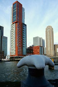 Modern sculpture by river against buildings in city