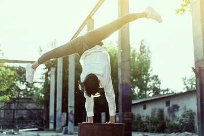 Low angle view of man doing handstand against sky