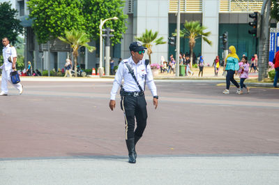 Full length of man walking on street in city