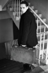 Young man holding briefcase on steps