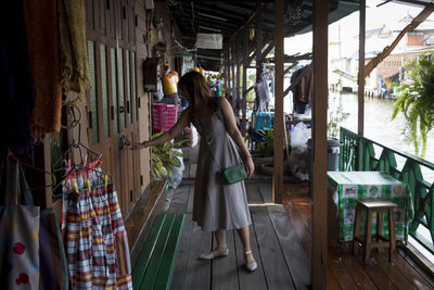 Woman standing and knocking at front door