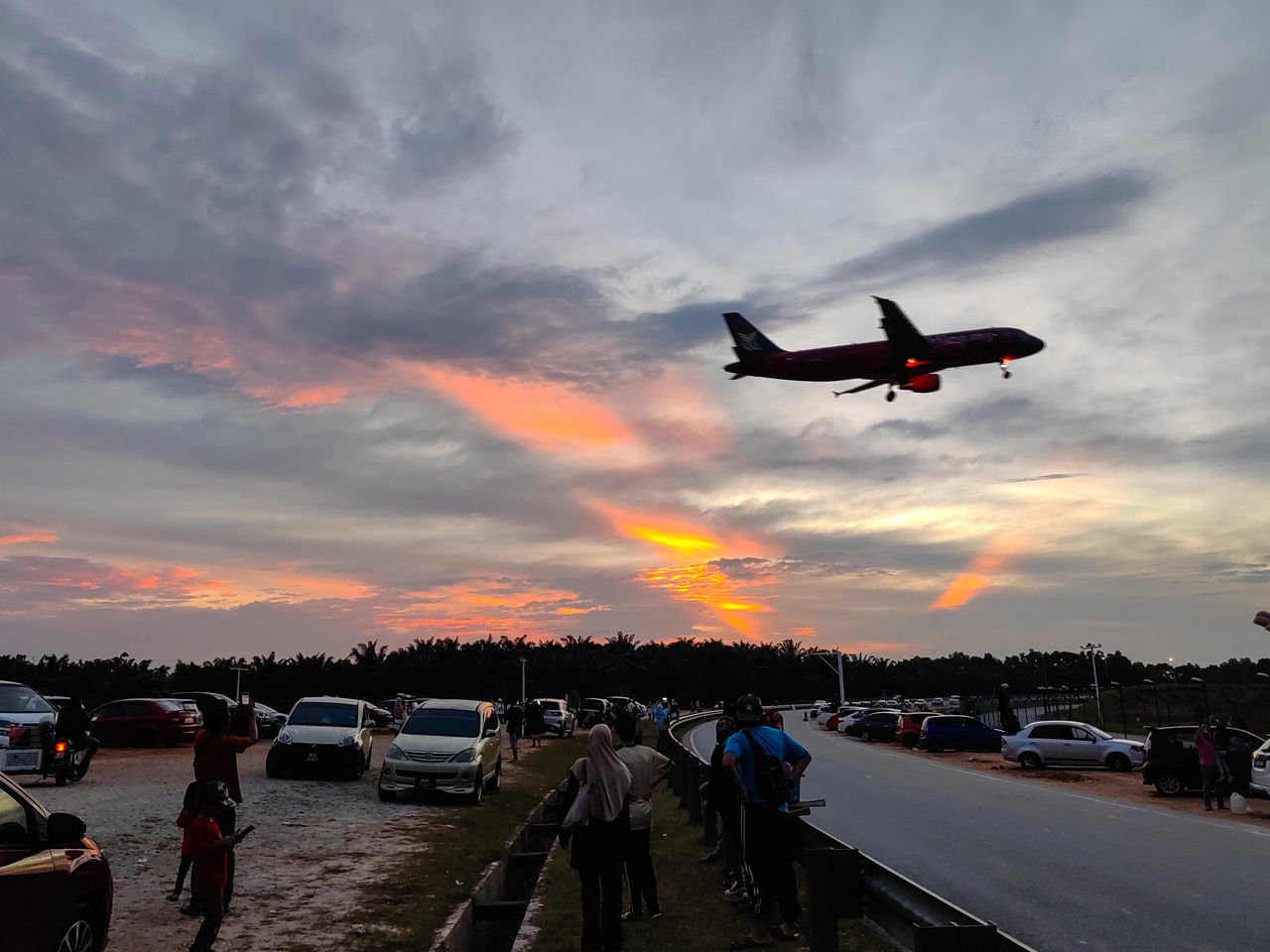 transportation, mode of transportation, sky, sunset, air vehicle, cloud, airplane, vehicle, flying, nature, car, motor vehicle, travel, aircraft, dusk, motion, aviation, evening, airport, on the move, orange color, architecture, dramatic sky, land vehicle, outdoors, city, sea, airport runway, silhouette, road