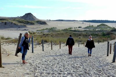 Rear view of people walking on beach