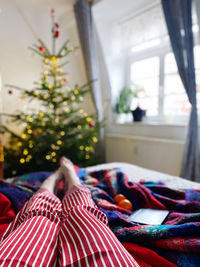 Low section of person woman relaxing on bed at home at christmas 