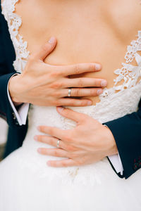 Midsection of couple holding hands