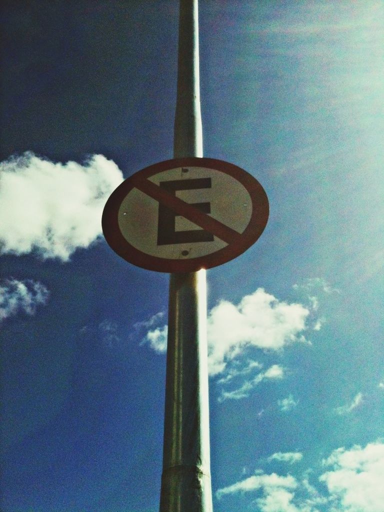 low angle view, communication, sky, text, road sign, guidance, cloud - sky, pole, sign, western script, information sign, cloud, blue, lighting equipment, street light, no people, information, day, arrow symbol, cloudy