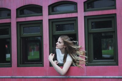 Portrait of woman in pink glass window