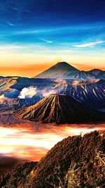 Aerial view of landscape against cloudy sky during sunset