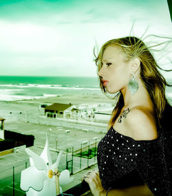 Woman looking at sea shore against sky