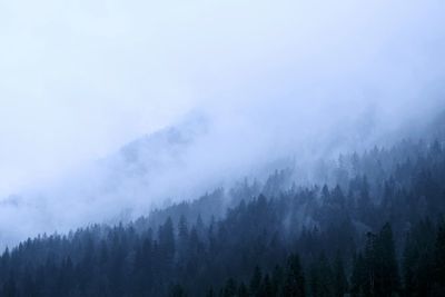 Scenic view of fog in mountains against cloudy sky