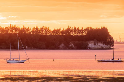 Motuhoa island at sunset. sailboats in silhouette.