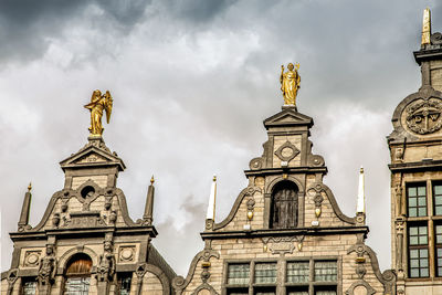 Low angle view of statue of building against cloudy sky