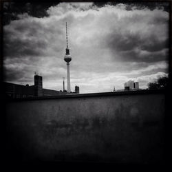 Communications tower against cloudy sky