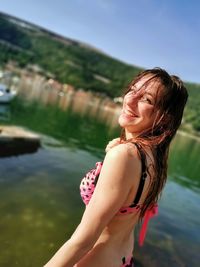 Portrait of smiling young woman standing in lake