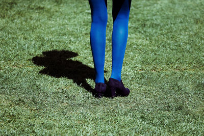 Low section of woman standing on field