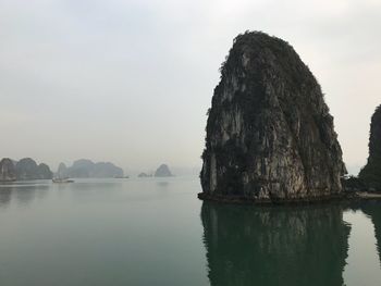 Rock formation in lake against sky