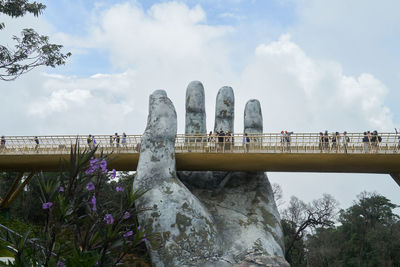 Bridge over river against cloudy sky