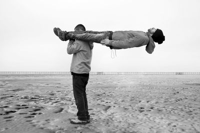 Rear view of man standing on beach