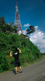 Rear view of woman by tree against sky