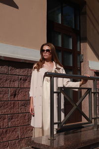 Portrait of young woman wearing sunglasses standing outdoors