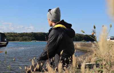 Rear view of man standing by water