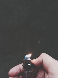 Close-up of hand holding lit candle