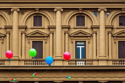 Multi colored balloons against building